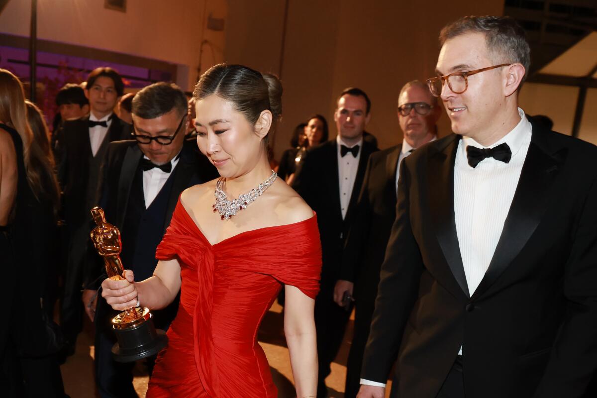 Maggie Kang looks at her Oscar at the Governors Ball.