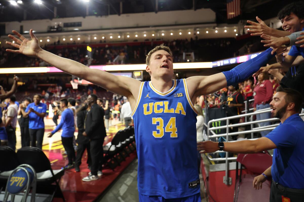 UCLA forward Tyler Bilodeau is congratulated by fans after beating USC at the Galen Center on March 7.
