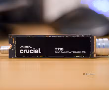 The Crucial T710 NVMe SSD propped up on a desk by a metal screwdriver.