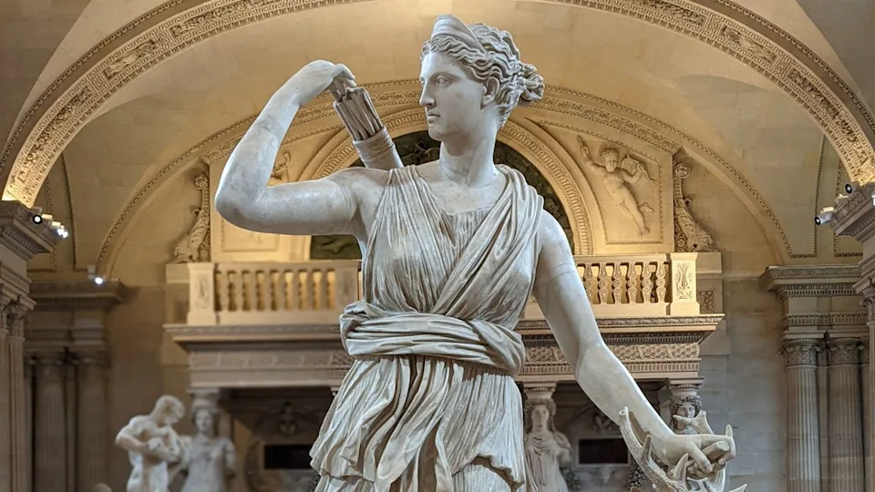  A statue of a female figure holding a quiver of arrows. 