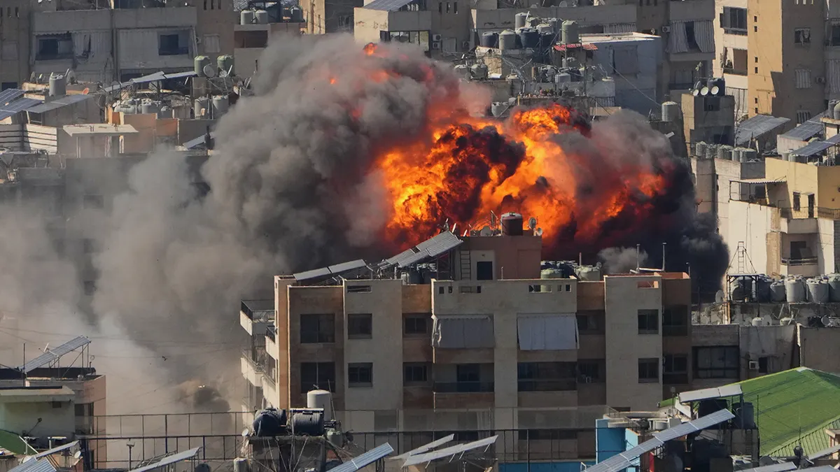 Large orange flames rising from a dense urban neighborhood.
