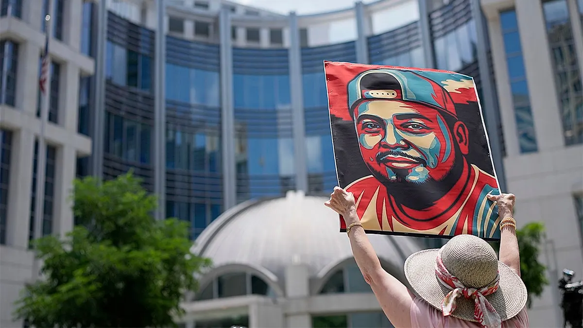A woman is seen holding a sign of Kilmar Abrego Garcia in front of the U.S. Court for the Middle District of Tennessee. Abrego Garcia was deported to El Salvador's CECOT prison earlier this year, in what Trump administration officials described as an 'administrative error.' Photo via Getty Images