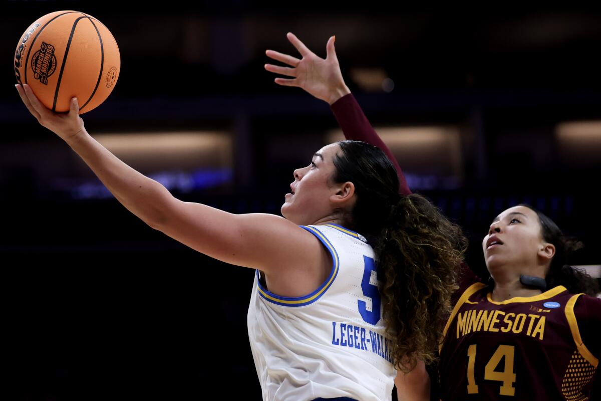 UCLA guard Charlisse Leger-Walker shoots in front of Minnesota guard Tori McKinney.