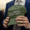 A closeup of a pair of hands clutching a green baseball cap that says "Make America healthy again." 