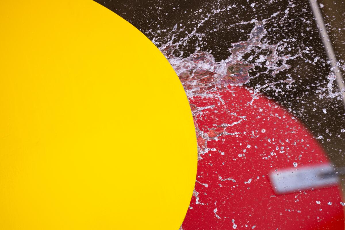 Water hits a red fountain paddle.