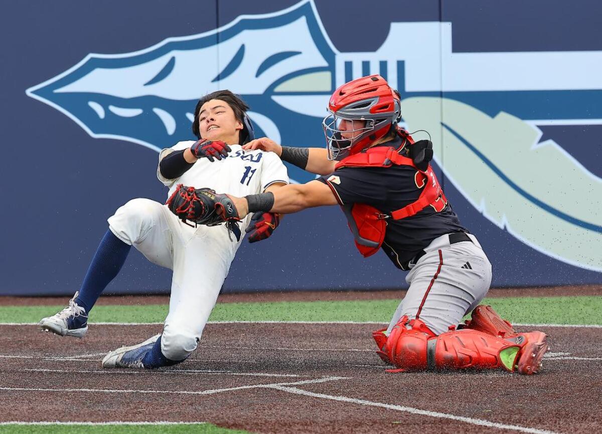 Catcher Brady Murrietta of Orange Lutheran makes the tag at home plate against St. John Bosco.