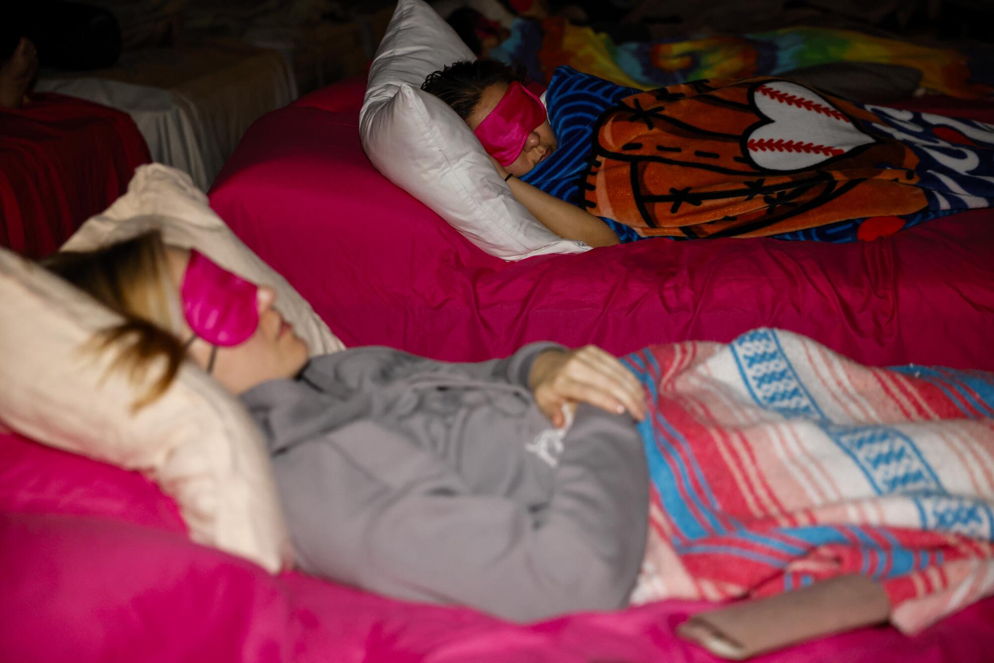Heather Fink, left, and Nubia Jimenez, right, recline and wear sleep masks during a relaxing sound bath.