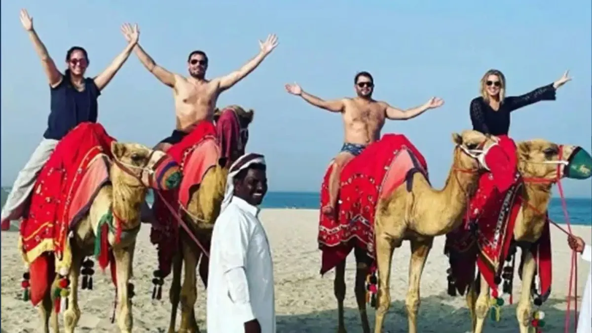 Then-Rep. Ruben Gallego and Rep. Eric Swalwell with their wives riding camels shirtless in Qatar