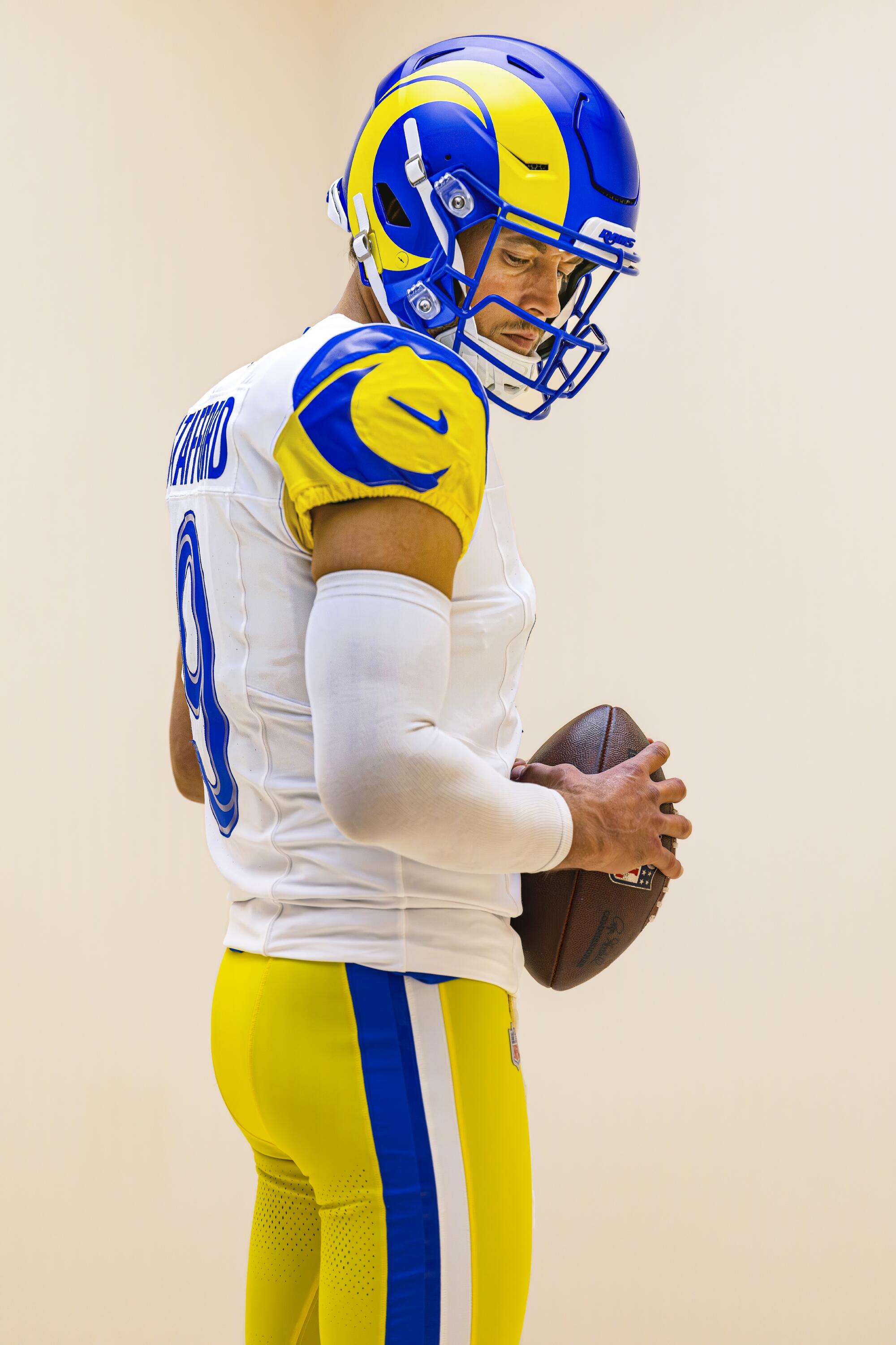 Matthew Stafford shows off the Rams' new white uniforms with yellow and blue accents on the sleeves.