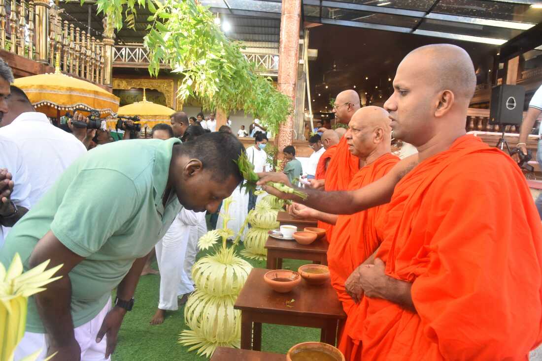 People participate in an oil anointing ceremony for the Sinhala and Tamil New Year at the Gangaramaya Temple in Colombo, Sri Lanka