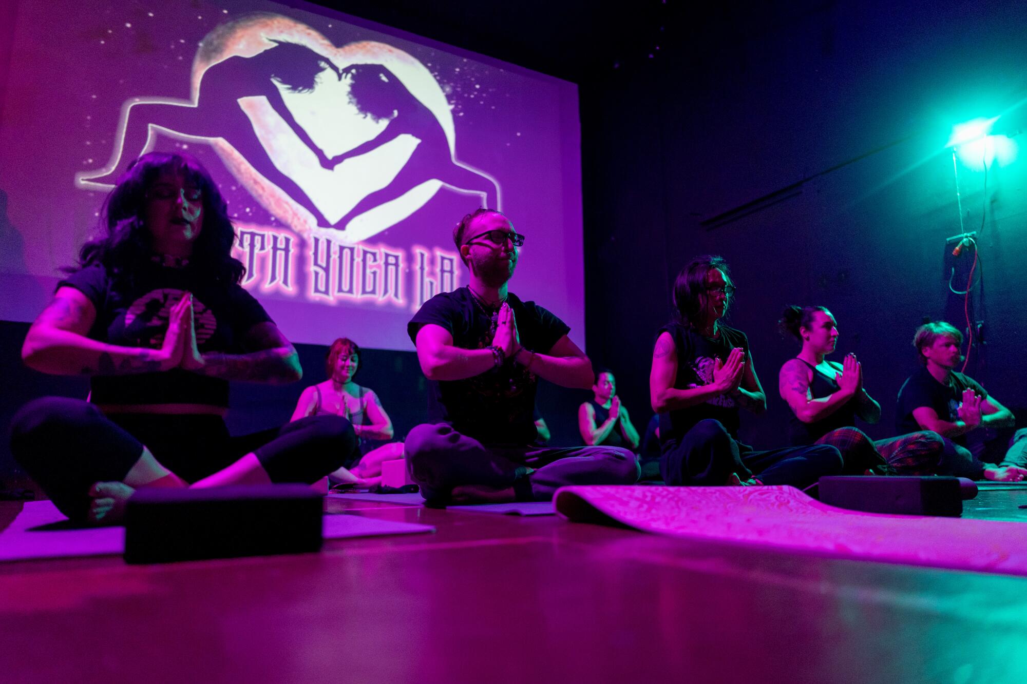Goth Yoga LA participants hold their hands in prayer. 