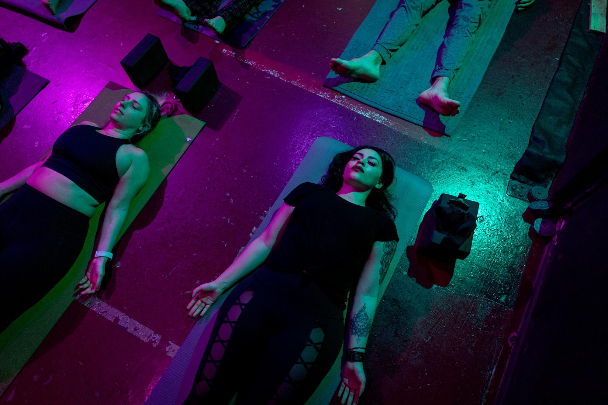 Goth Yoga LA class participants Ellie Albertson and Jenn Rivera recline in corspe pose.