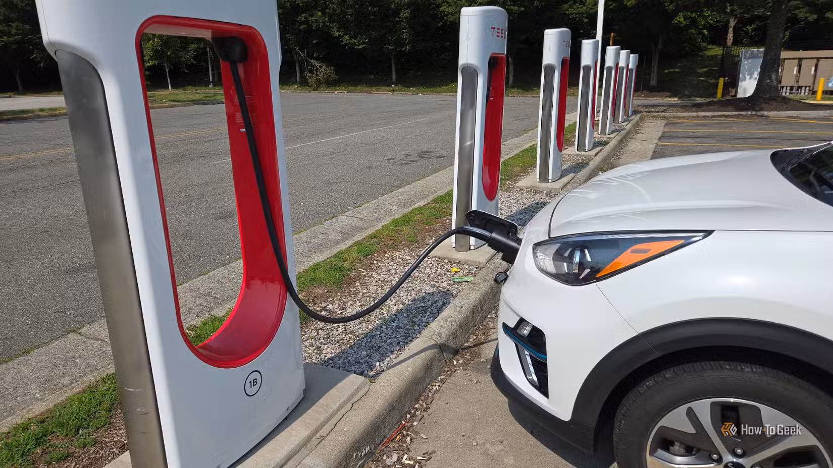 A Kia Niro EV charging at a Tesla Supercharger stall.