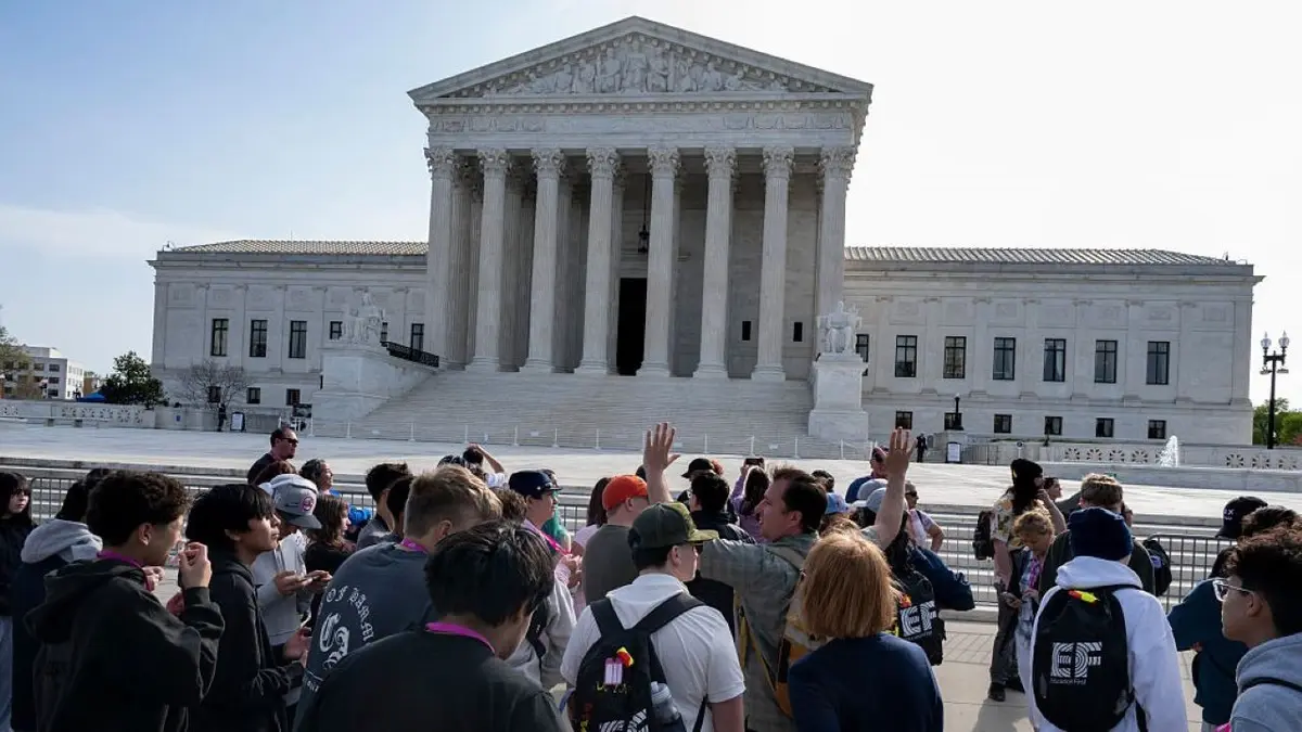 people stand in front of the Supreme Court