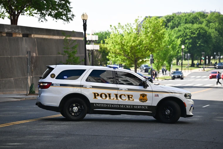 A police car parked horizontally on a street across a double yellow line