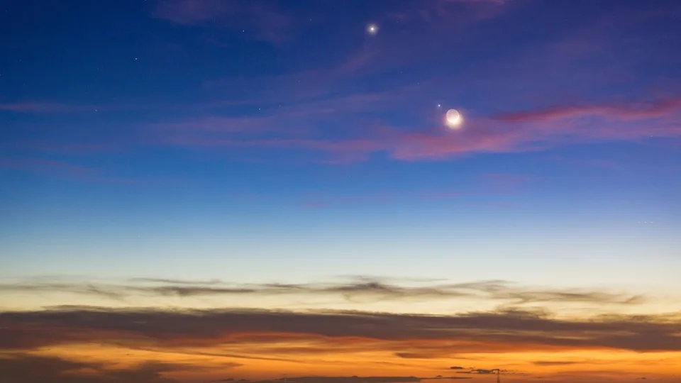  Image of the moon shining close to venus and jupiter in the post sunset sky. 