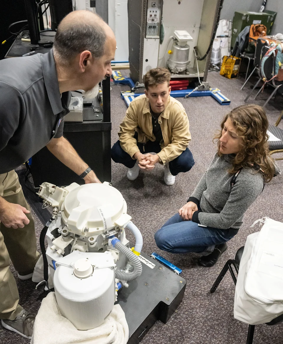 NASA astronaut Christina Koch works with a test version of the Orion space toilet.