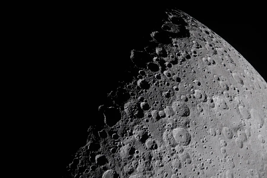A view of the moon's surface in striking detail, full of craters.