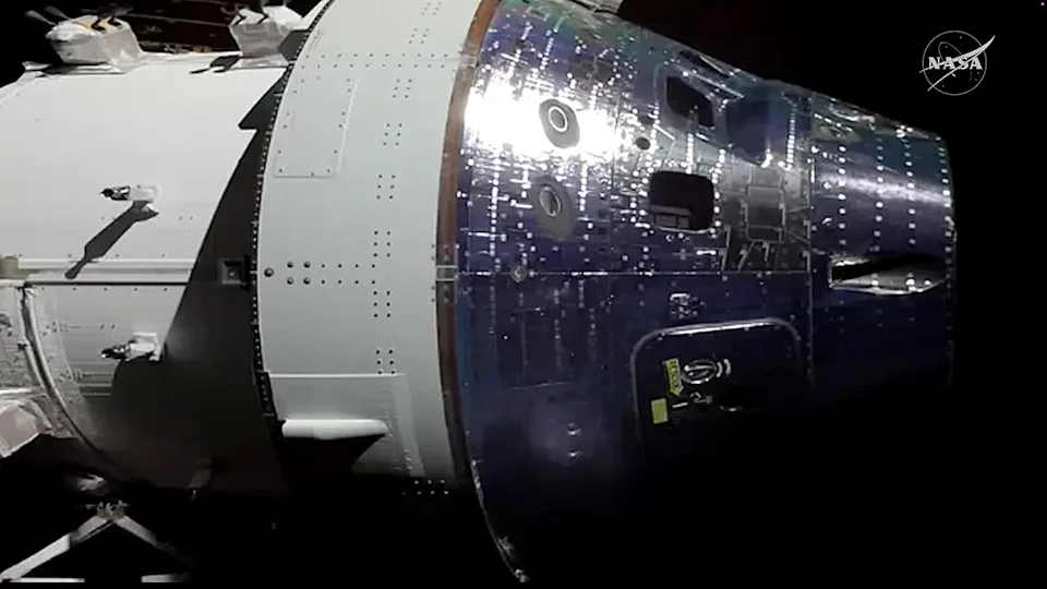 Another solar wing camera was aimed at the Orion spacecraft after the ship was maneuvered to put a waste water vent nozzle in direct sunlight. The goal was to warm it up enough to thaw out suspected ice in a waste line preventing flight controllers from emptying a urine collection tank used by the capsule's toilet. / Credit: NASA