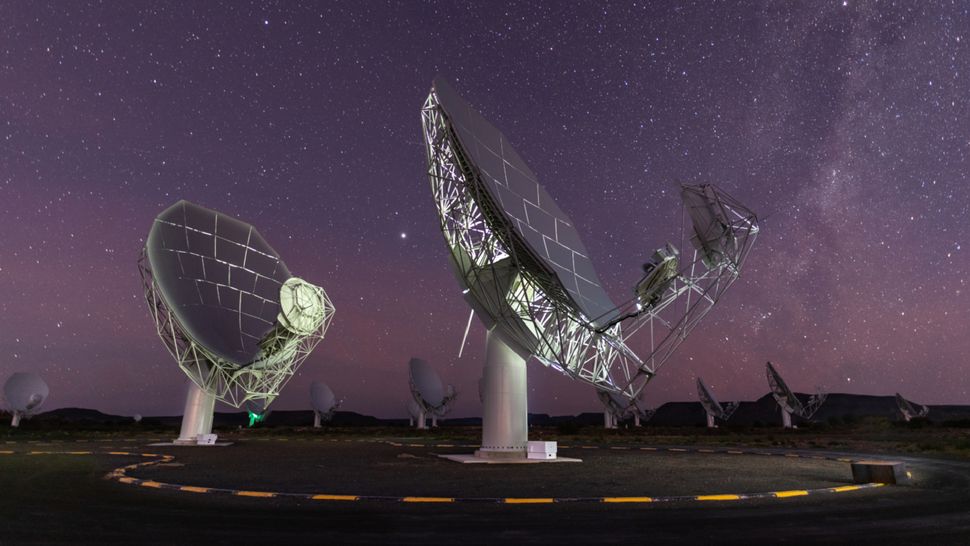 A group of satellite dishes under a starry sky