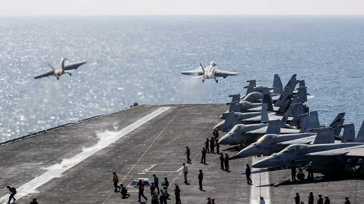 Two F/A-18 Super Hornets launching from USS Abraham Lincoln flight deck