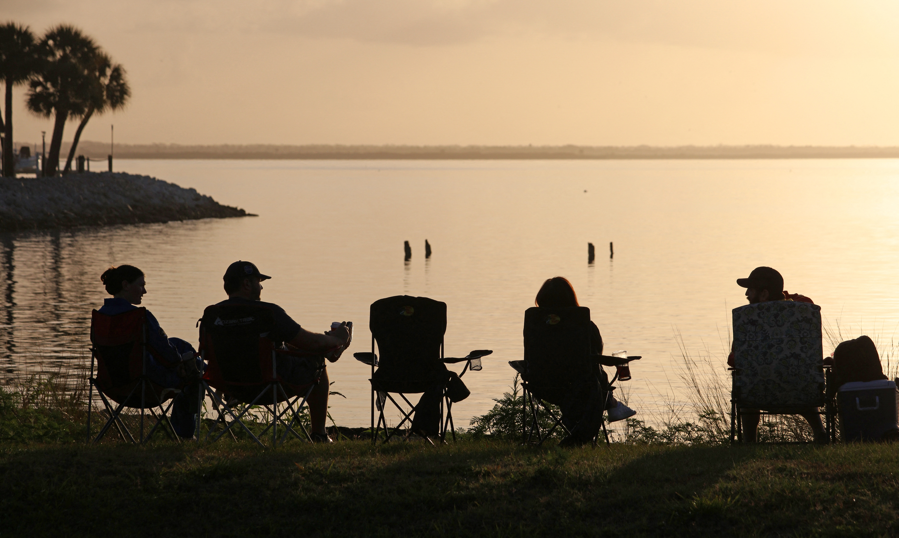 Space enthusiasts watch the sunrise from a park in Titusville, Florida several hours before NASA's Artemis II Space Launch System (SLS) rocket is scheduled to launch from the Kennedy Space Center on April 1, 2026.