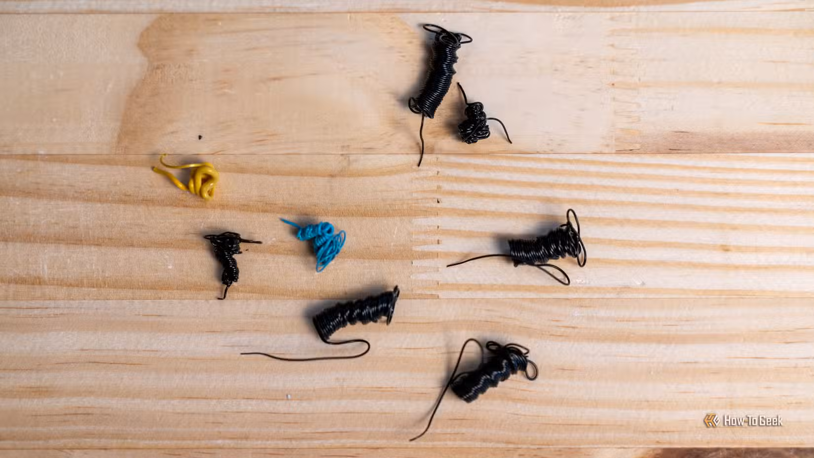 3D printer "poop" or filament purge sitting on a wooden desk.