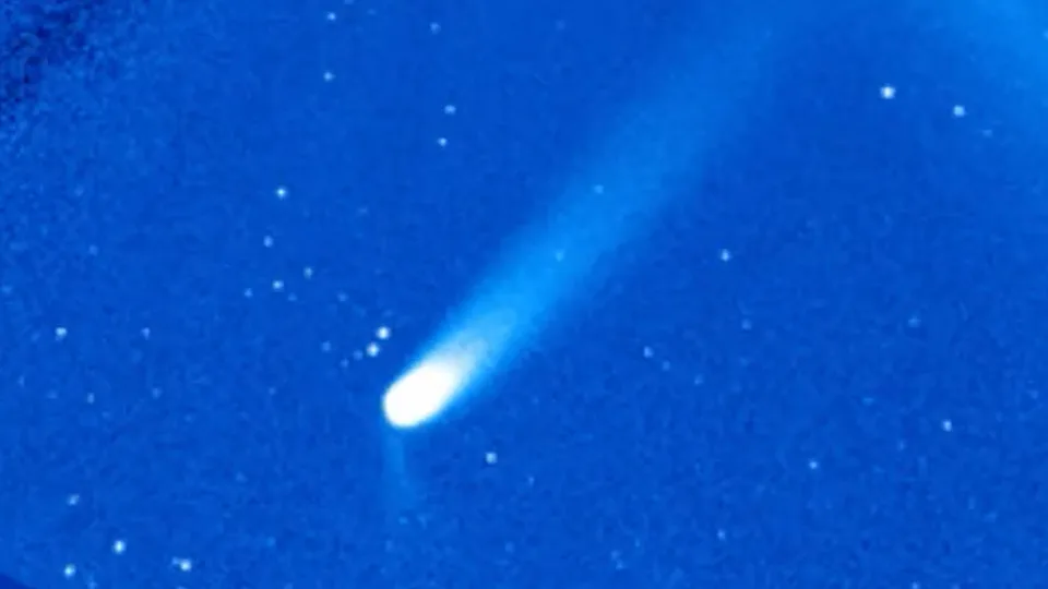  A comet is pictured in a coronagraph with a large sweeping tail extendin to the upper right of the screen. 