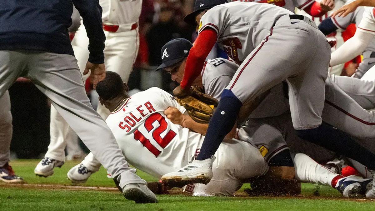 Los Angeles Angels' Jorge Soler tackled to the ground by Atlanta Braves players during a baseball game