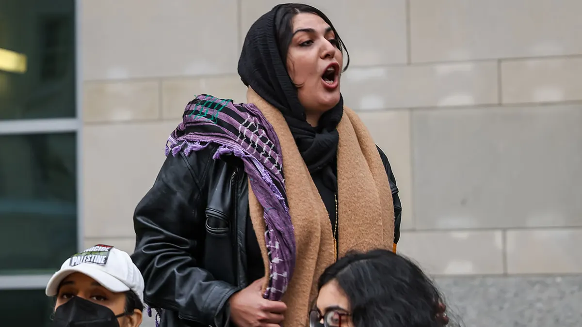 Nerdeen Kiswani speaking at a rally outside the AirTrain at Jamaica station in Queens, New York