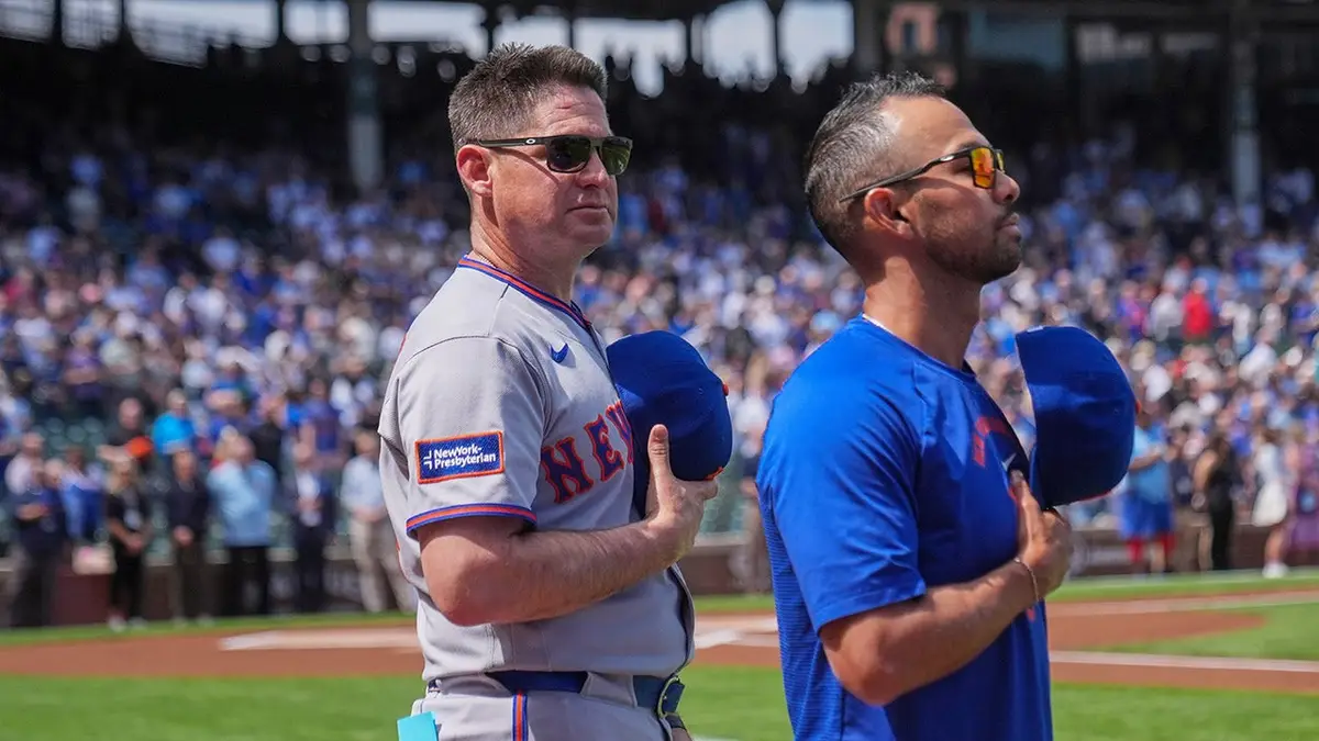 New York Mets manager Carlos Mendoza standing during the Star-Spangled Banner before a baseball game