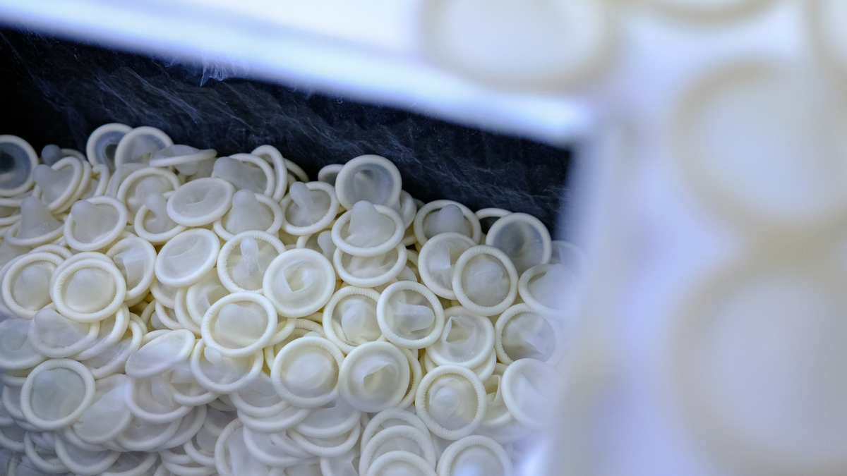 Condoms sit on a container on the production line at a Karex Bhd. facility in Port Klang, Selangor, Malaysia.