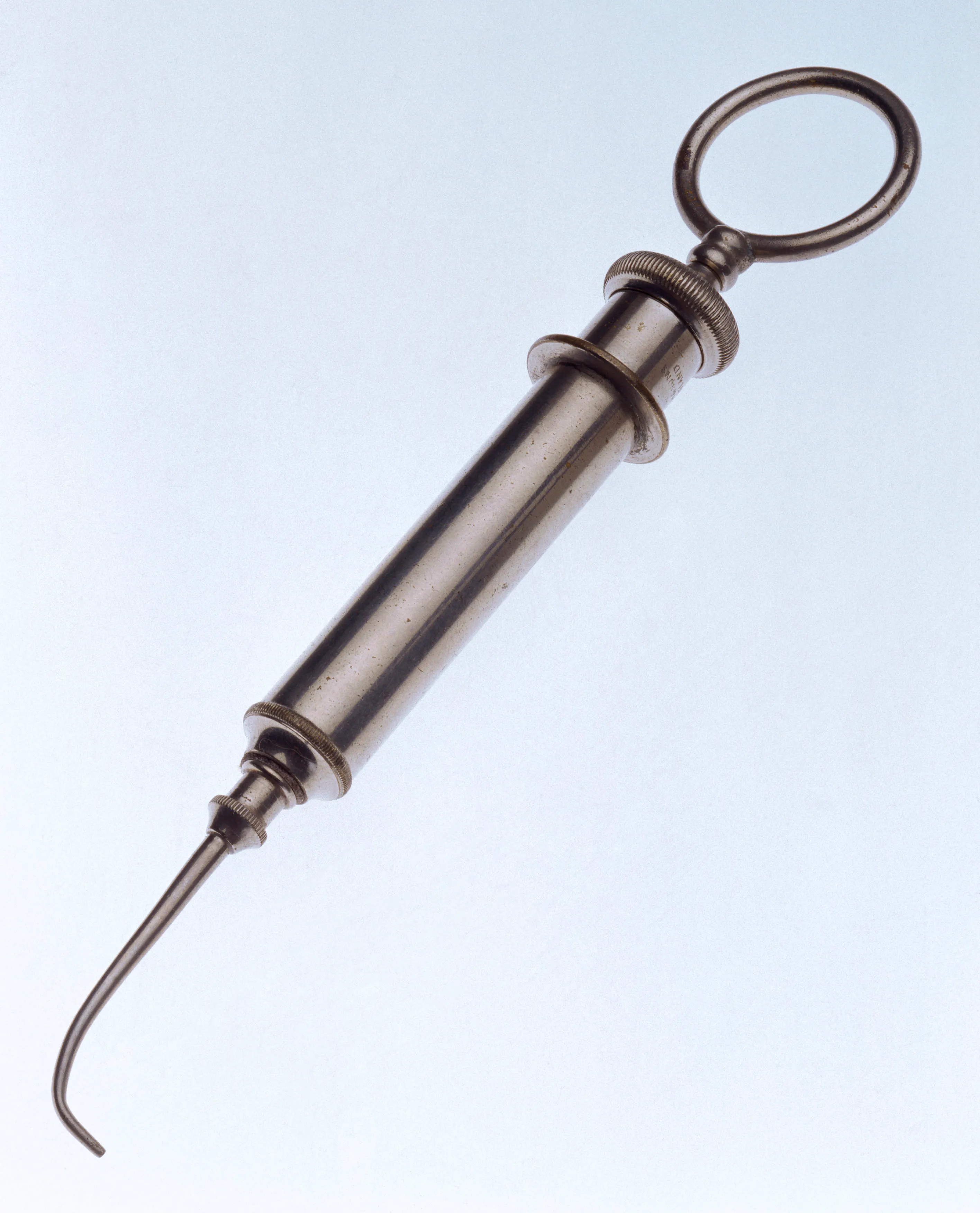 A nickel-plated brass water syringe made by Claudius Ash and Sons, England. The water syringe is used by dentists to rinse the surface of the tooth clean prior to treatment. 