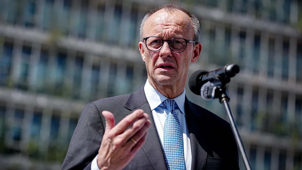 German Chancellor Friedrich Merz speaking at a podium during a trip to India