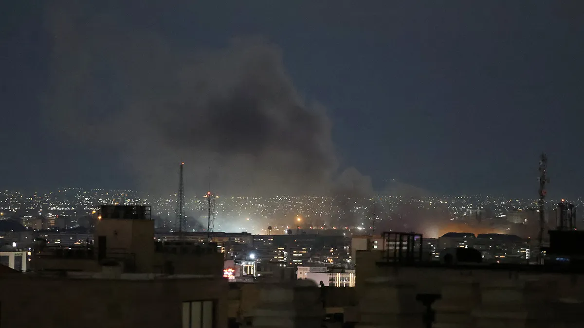 A plume of smoke rising from a strike site in Tehran