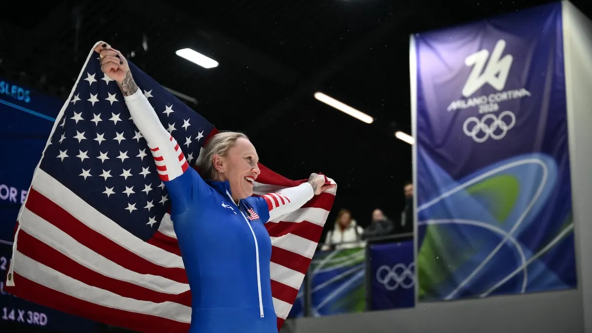 Kaillie Humphries holding a USA flag after bobsleigh women's monobob race