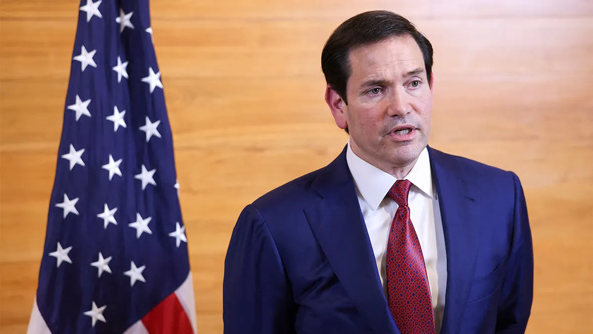 Secretary of State Marco Rubio speaking to reporters at an airport terminal