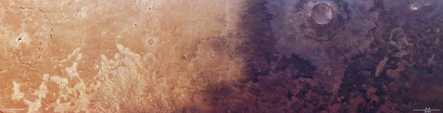 Long aspect-ration aerial photo of the surface of Mars, with the right half shrouded in shadow.