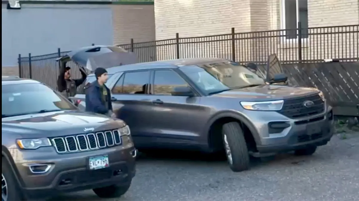 Police officers standing between two cars