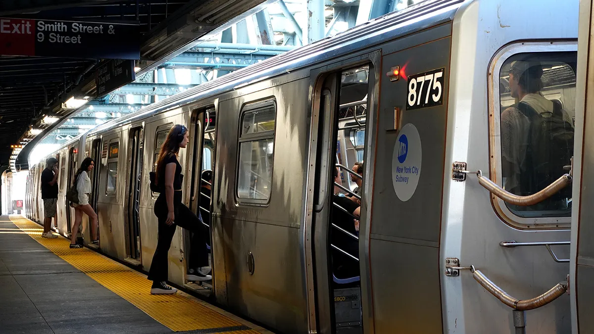 People boarding an F-line train at Smith Street - 9th Street subway station in New York City