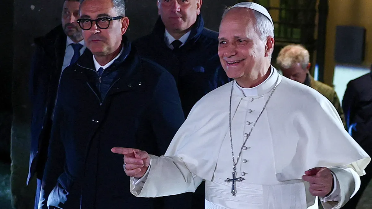 Pope Leo XIV gesturing while walking outside the papal residence in Castel Gandolfo