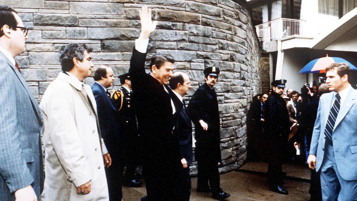 President Ronald Reagan waving to onlookers outside the Washington Hilton