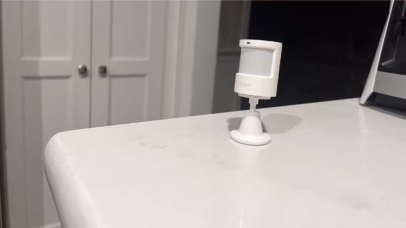 An Aqara Light and Motion Sensor P2 sitting on a countertop.