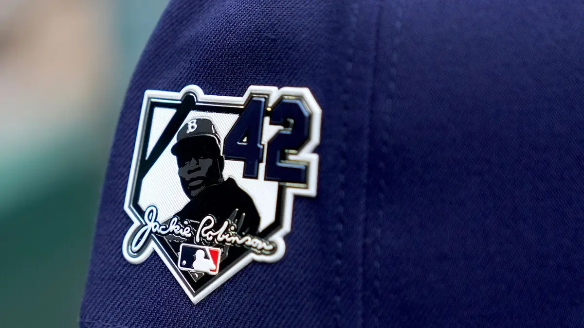 A Tampa Bay Rays hat with a Jackie Robinson Day patch on a baseball field.
