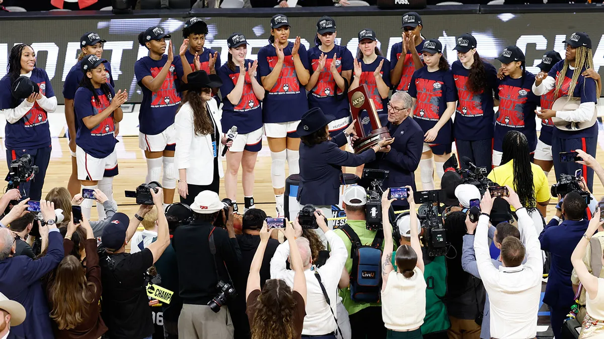UConn Huskies players holding Fort Worth Regional trophy at Dickies Arena