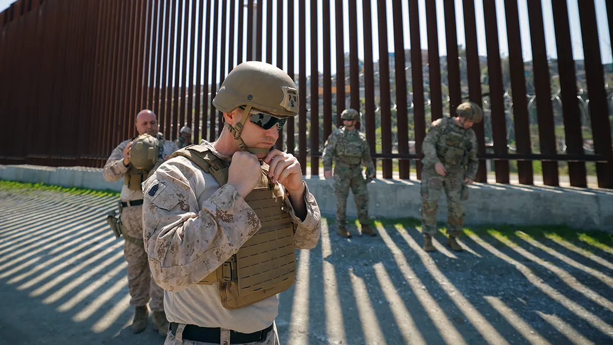 A member of Sapper Taskforce standing near the border wall in San Diego