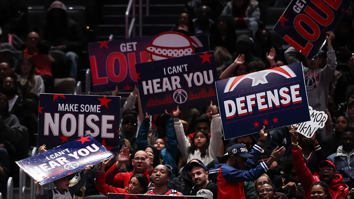 Washington Wizards fans holding signs during basketball game at Capital One Arena