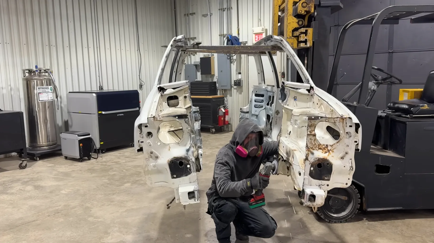 a man wearing a gas mask between a car that's split in half