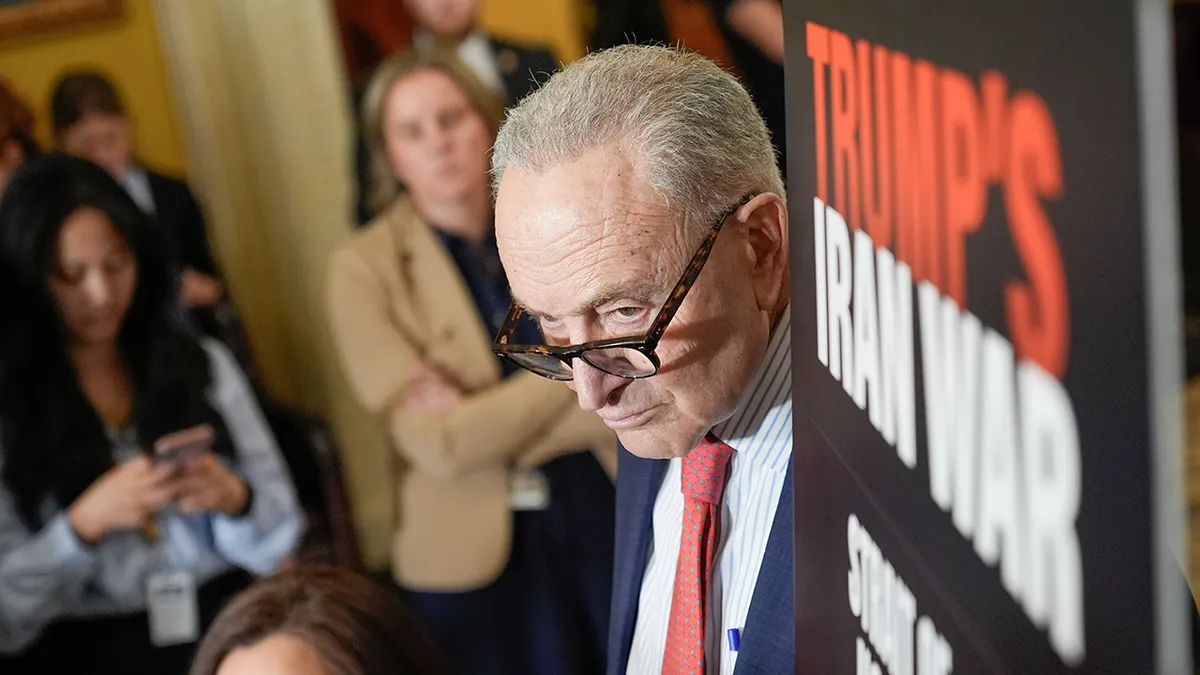 Senate Minority Leader Chuck Schumer standing at a podium during a news conference
